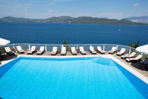 Una piscina al aire libre de temporada, sombrillas