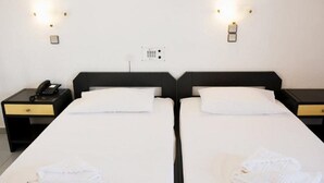 Ein Doppelzimmer mit zwei Betten, Nachttischen mit Lampen und einer Steckdose.