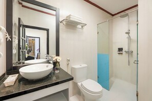 Un bagno con un ampio specchio, due lavabi, un WC e una zona doccia.