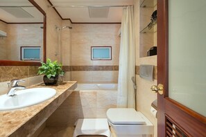 A bathroom with a sink, toilet, shower, and bathtub.