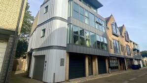 Un immeuble moderne à plusieurs étages, doté de grandes fenêtres, d’un toit plat et d’une façade en briques.