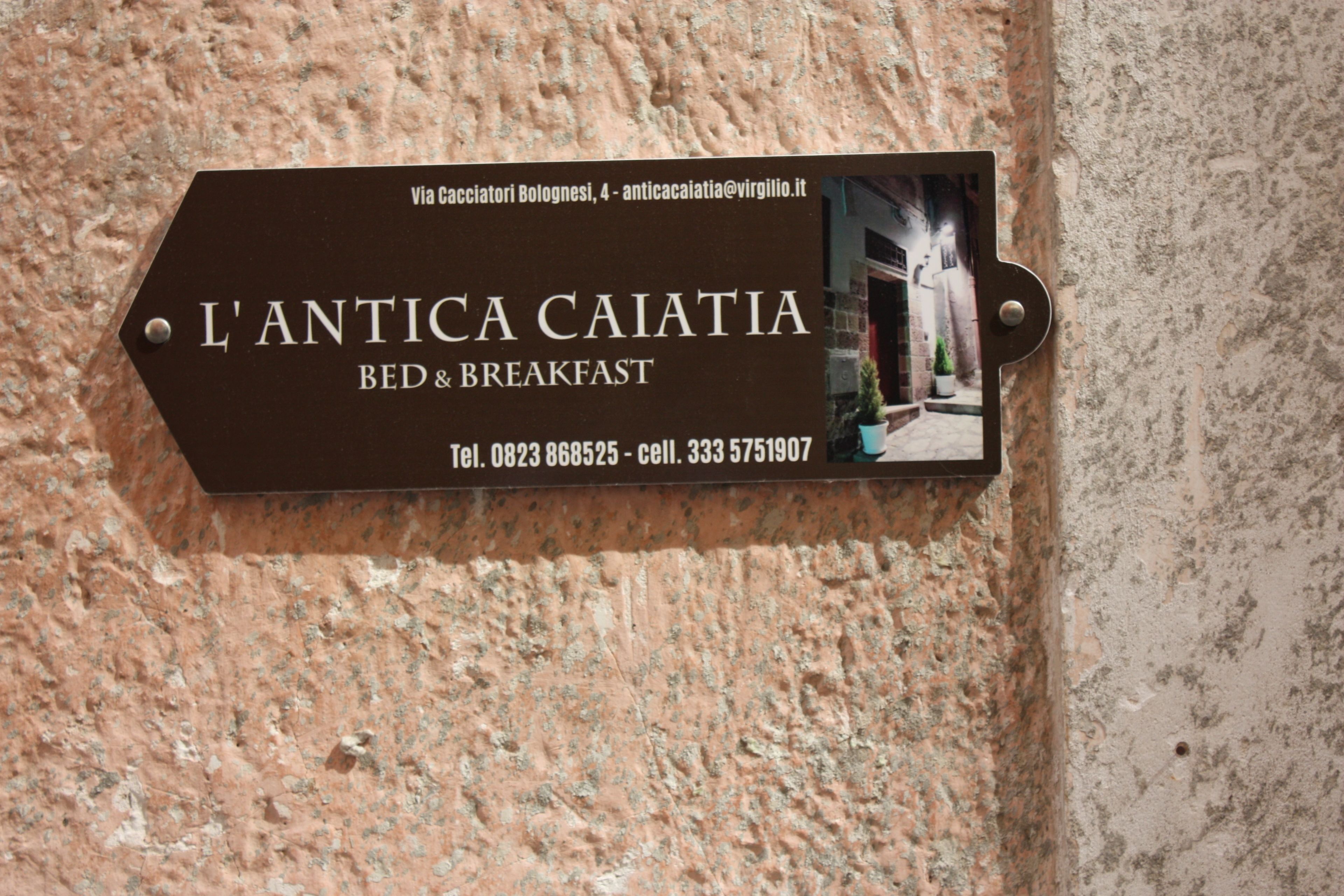 Señalización para el Bed & Breakfast L'Antica Caiatia, con información de contacto y una foto del edificio.