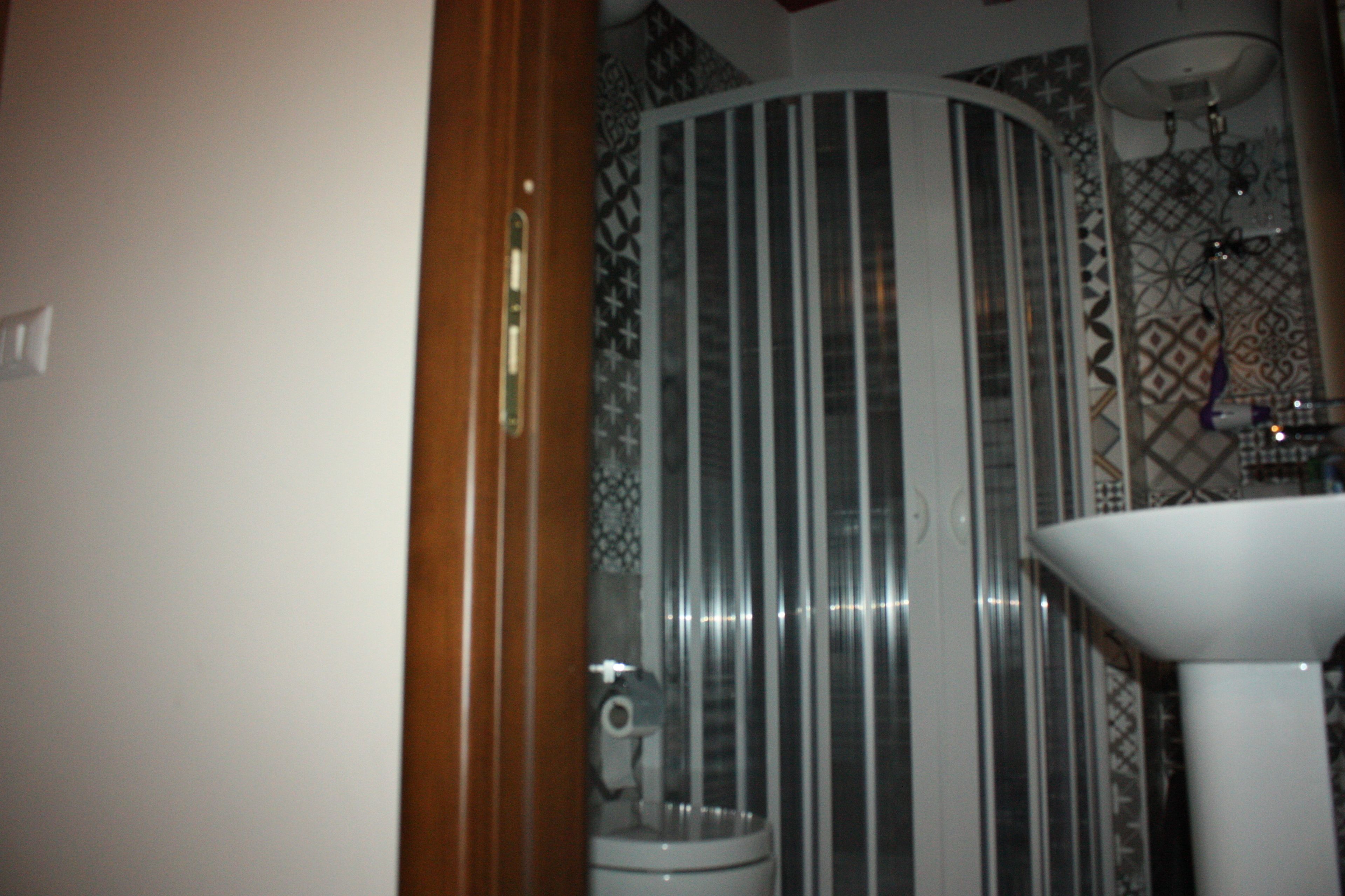 A bathroom with a toilet, a sink, and a shower area.