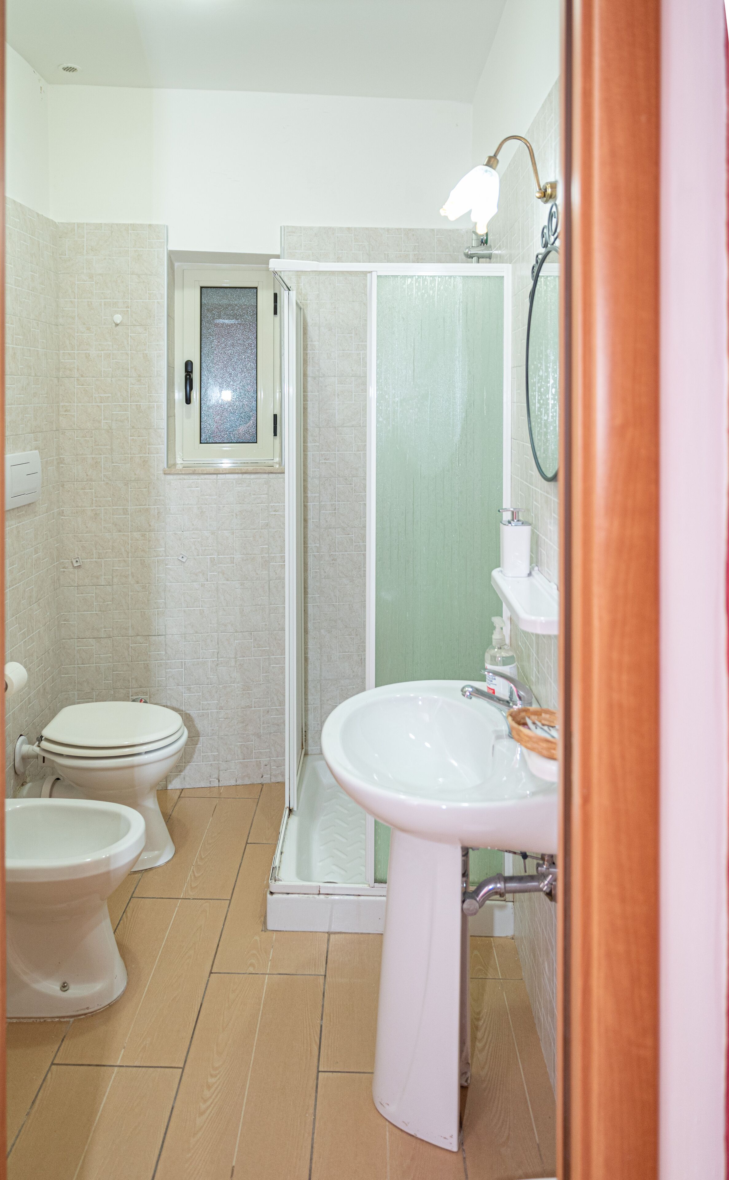 Ein Badezimmer mit zwei Toiletten, einer Dusche und einem Waschbecken.