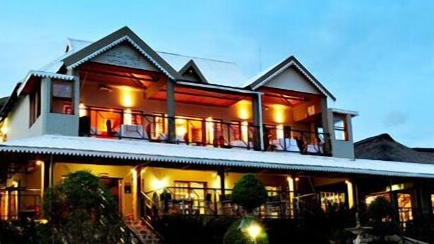 A two-story building with a balcony and a covered outdoor area. - Villa Paradiso Country Manor (Hartbeespoort)