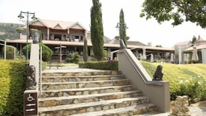 A stone staircase leading to a building with a wheelchair-accessible ramp. - Villa Paradiso Country Manor (Hartbeespoort)