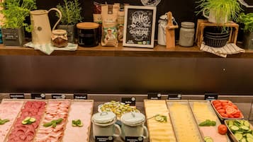 A buffet with various food items including meats, cheeses, and vegetables.