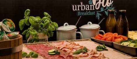 A breakfast buffet with various meats, vegetables, and a sign reading "urban breakfast".