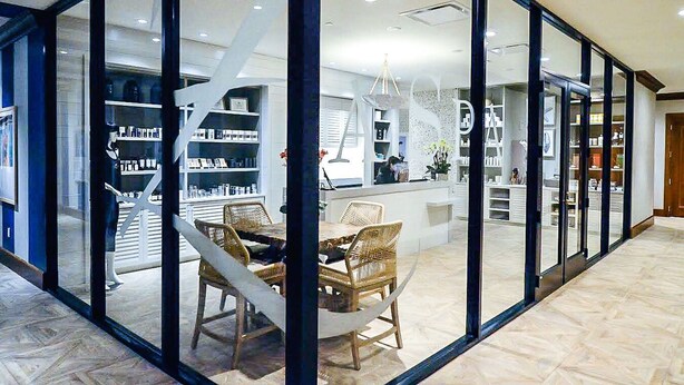 A modern interior with glass walls, a central seating area, and a staircase leading to upper levels. - Hotel ZaZa Houston Memorial City (Houston)