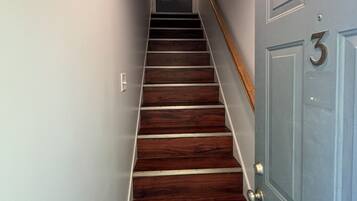 Una escalera de madera con peldaños que lleva a una puerta con el número 3.