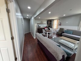 Un espacio habitable compacto con kitchenette, comedor y sofá.