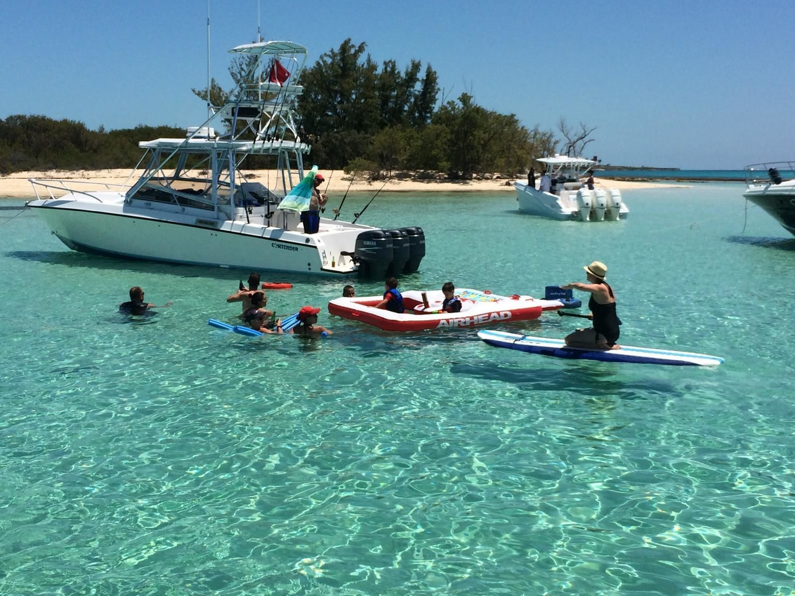 A boat with people on the water, a lifeguard tower, and a beach in the background.