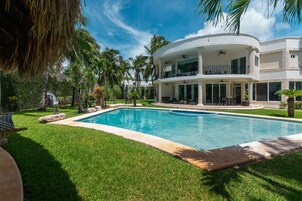 Una piscina al aire libre, sillones reclinables de piscina