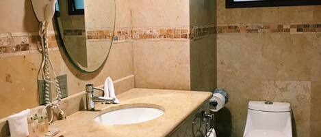 A bathroom with a sink, mirror, towel rack, and toilet.