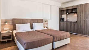 A hotel room with two beds, a kitchenette, and a large wardrobe. - Gerona Mare (Platanias)