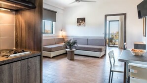 A modern kitchen with a built-in stove, a wooden cabinet, and a ceiling fan. - Gerona Mare (Platanias)
