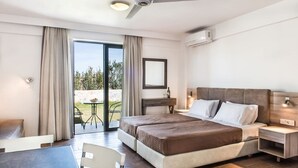 A hotel room with a bed, a desk, a chair, and a balcony with a table. - Gerona Mare (Platanias)