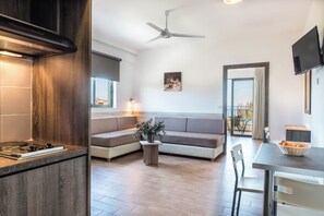 A modern kitchen with a built-in stove, a wooden cabinet, and a ceiling fan. - Gerona Mare (Platanias)