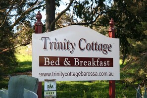 A sign for Trinity Cottage Bed & Breakfast with a website URL.