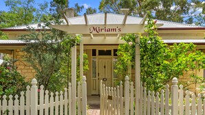 A white picket fence entrance to a building with a sign reading "Miriam's". - Miriams Cottage (Tanunda)