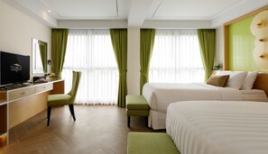Een hotelkamer met een bed, een televisie, een bureau en een stoel.