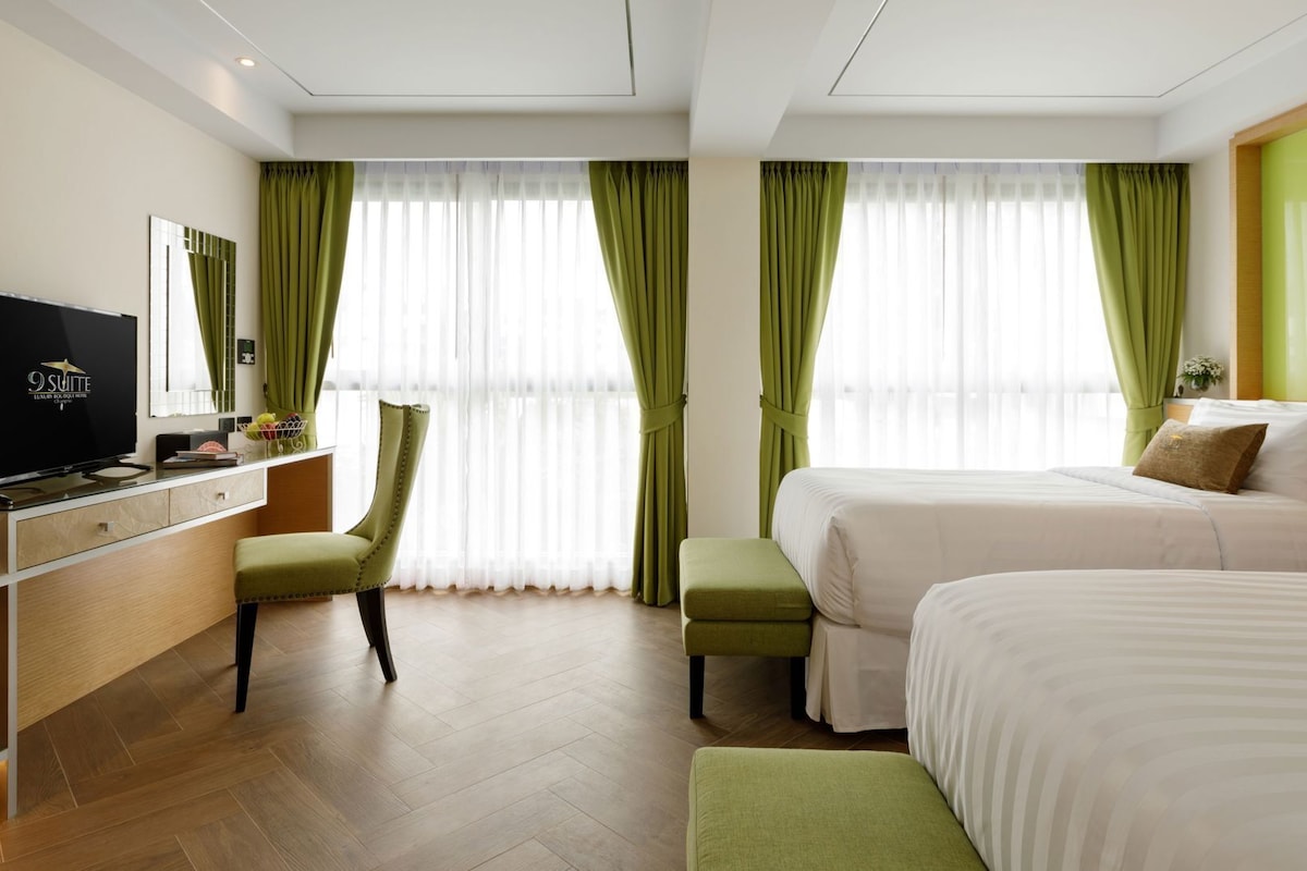 Ein Hotelzimmer mit Bett, Schreibtisch mit Fernseher und Stuhl.