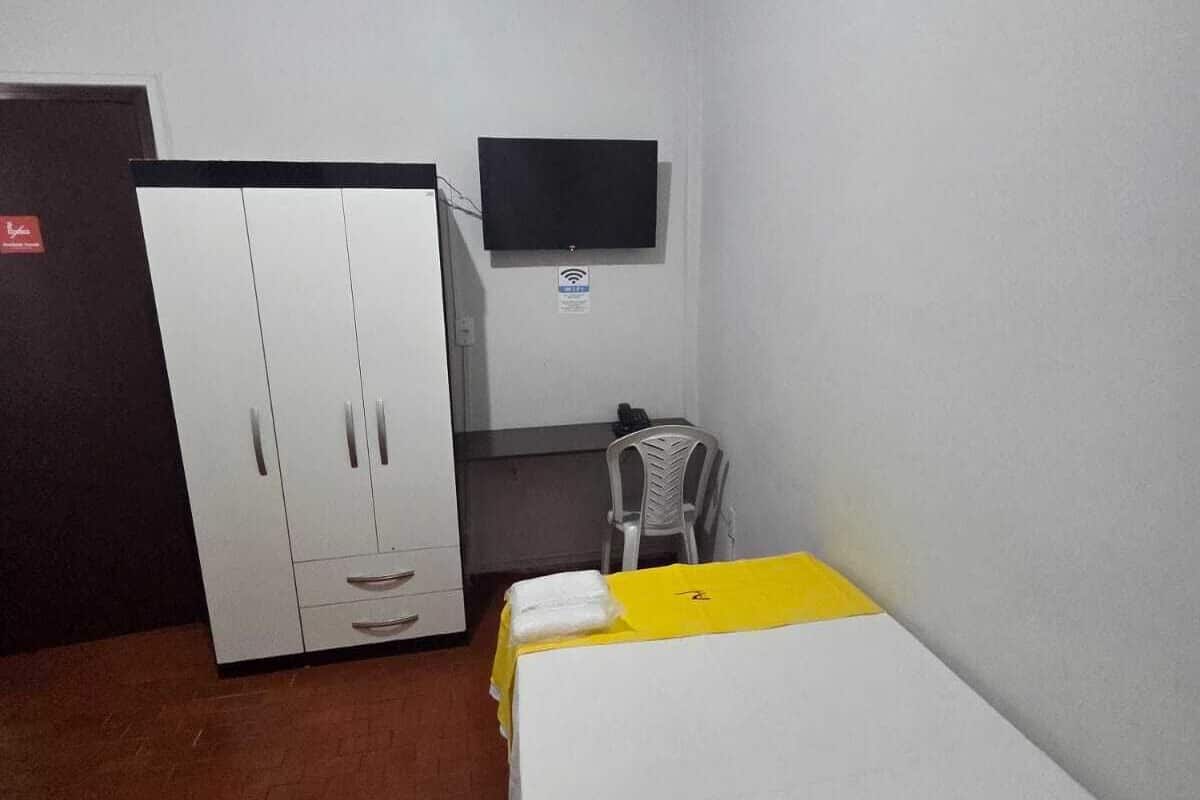 A room with a bed, a wardrobe, a desk, and a television.