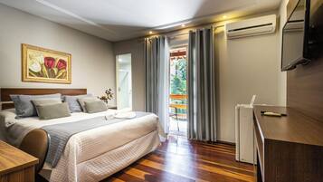 Habitació d'hotel amb llit, escriptori, aire condicionat, televisió i un quadre a la paret.