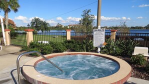 A hot tub with a metal ladder, surrounded by a brick border and greenery. - Holiday home winter / summer (Winter Garden)