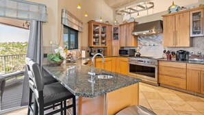 A modern kitchen with granite countertops, wooden cabinets, and stainless steel appliances. - Tucson Hilltop Estate: Sleeps 9, Heated Pool  & Spa, Game Room, Cantina, Gas BBQ (Tucson)