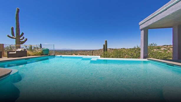 A clear blue swimming pool with a view of the desert landscape and cacti. - Tucson Hilltop Estate: Sleeps 9, Heated Pool  & Spa, Game Room, Cantina, Gas BBQ (Tucson)