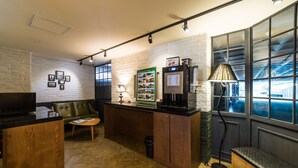 Una cocina moderna con encimera de madera, cafetera y un rincón de comedor con banco y mesa.