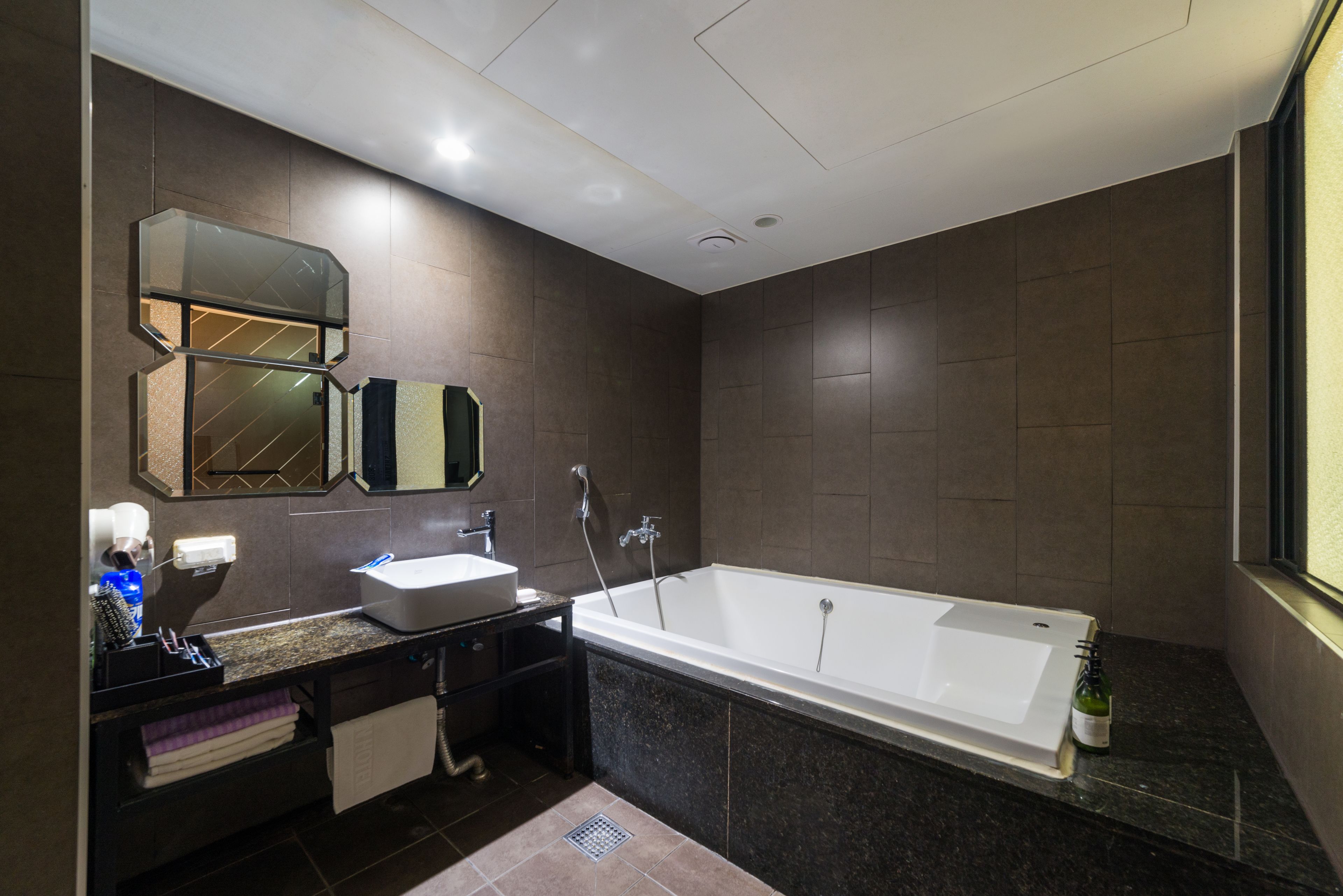 Un baño moderno con una bañera grande, un lavamanos y un espejo.