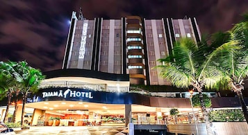Un hotel con diseño moderno, destacando un cartel prominente de 'TAIMÄ HOTEL' en la entrada.