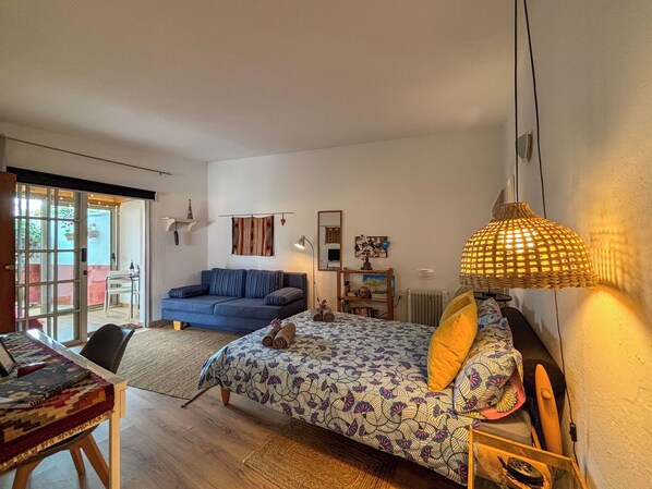 Un salon confortable avec un canapé, un lit, une table à manger et une lampe.