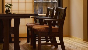 Ein traditioneller japanischer Raum mit Tatami-Böden, einem niedrigen Holztisch und einer hängenden Leuchte.