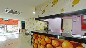 A reception area with a counter displaying oranges, a fire extinguisher, and a fan on the wall. - Hotel O Orange Hotel Kuala Pilah (Kuala Pilah)