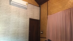 Ein Zimmer mit einer Ziegelwand, einer Holztür und einem Bett mit roten Handtüchern.