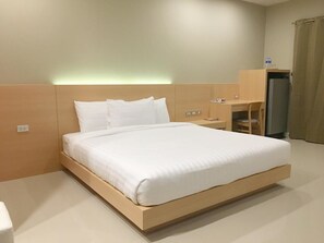 A modern hotel room with a large bed, a desk, and a wardrobe. - M-One Residence (Hat Yai)