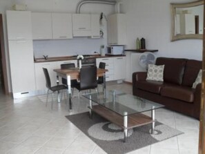 A compact living space with a kitchenette, a dining area, and a seating area.