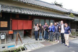 A traditional Japanese building with a tiled roof, wooden doors, and a signboard. - Asuka Guest House - Hostel (Asuka)