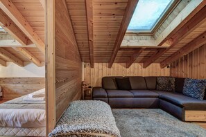 Ein Holzinnenraum mit Oberlichter, einer Couch und einem Bett.