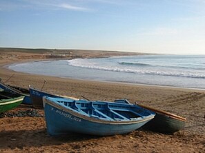 Ranta lähistöllä, aurinkotuoleja, rantapyyhkeitä