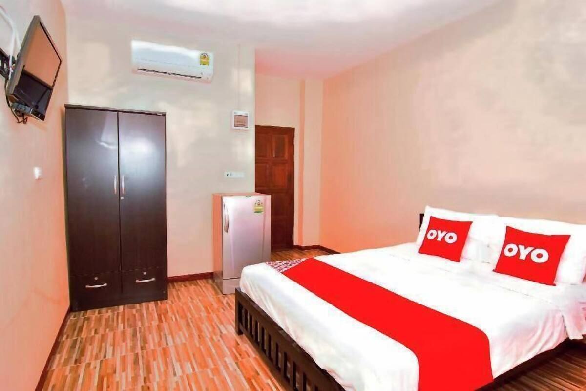 A hotel room with a bed, wardrobe, and a small refrigerator.