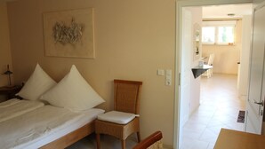 Ein Schlafzimmer mit einem Bett, einem Sessel und einem Bild an der Wand.