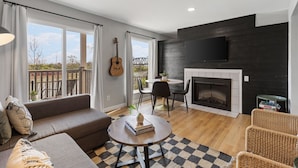 Una sala de estar moderna con chimenea, un sofá, una mesa de centro y un comedor.