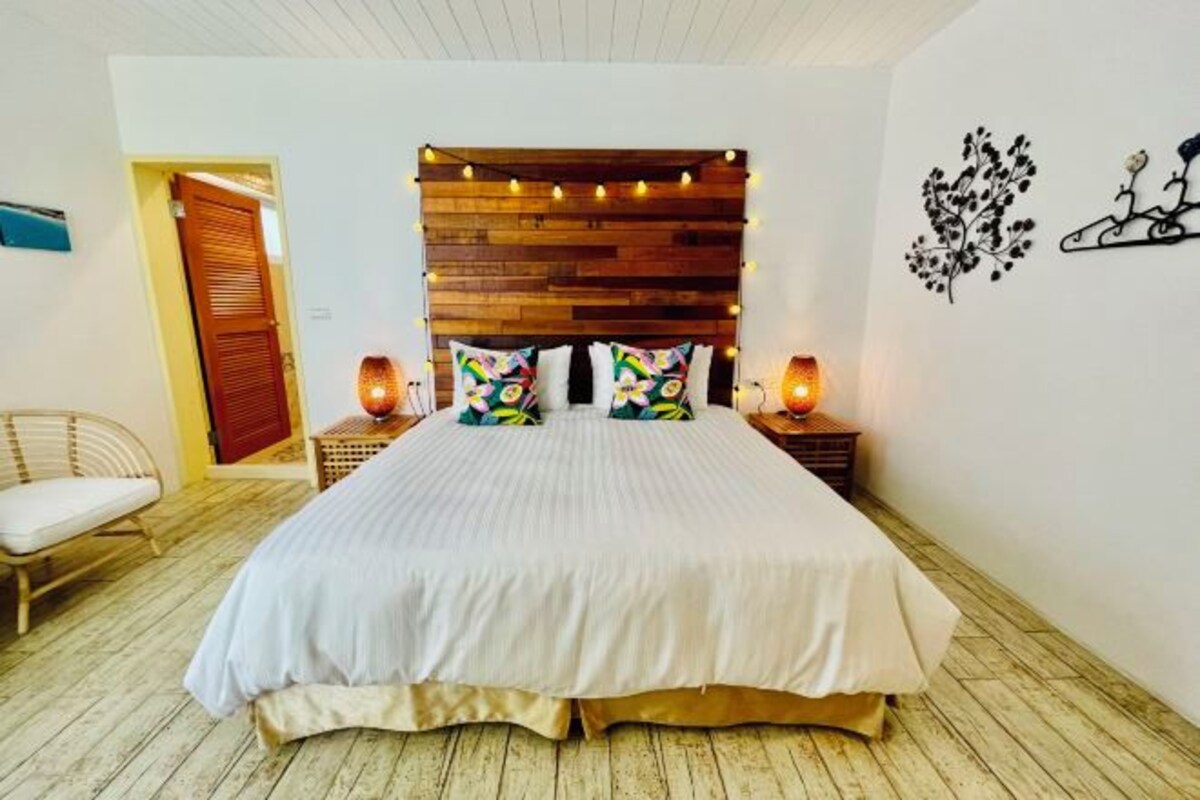 A bedroom with a wooden headboard, two bedside lamps, and a bed with white bedding.