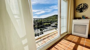 A balcony with a view of a green landscape and a road. - Spoondrift Hostal (Hengchun)