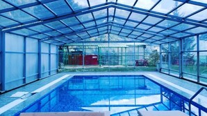 Una piscina de vidre, envoltada de gandules, amb vista a un paisatge de muntanya.