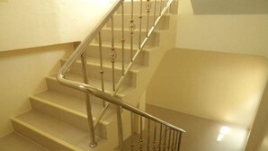 Un escalier avec une rampe en métal et des marches de couleur beige.